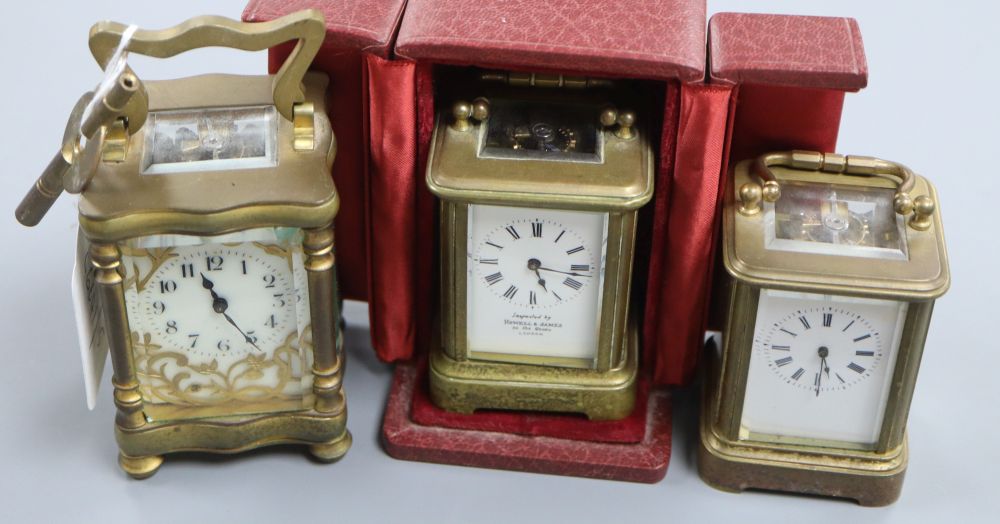 A cased lacquered brass miniature carriage timepiece and two others